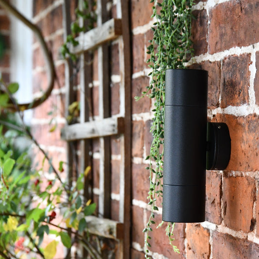 Modern Black Cylindrical Wall Spotlight mounted to a red brick wall