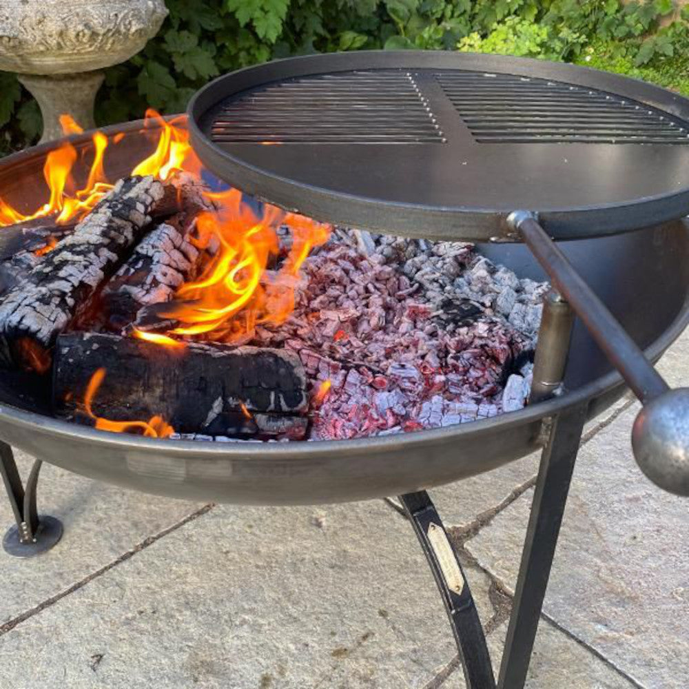 Close up of the fire bowl lit up warming up the swing arm grill 