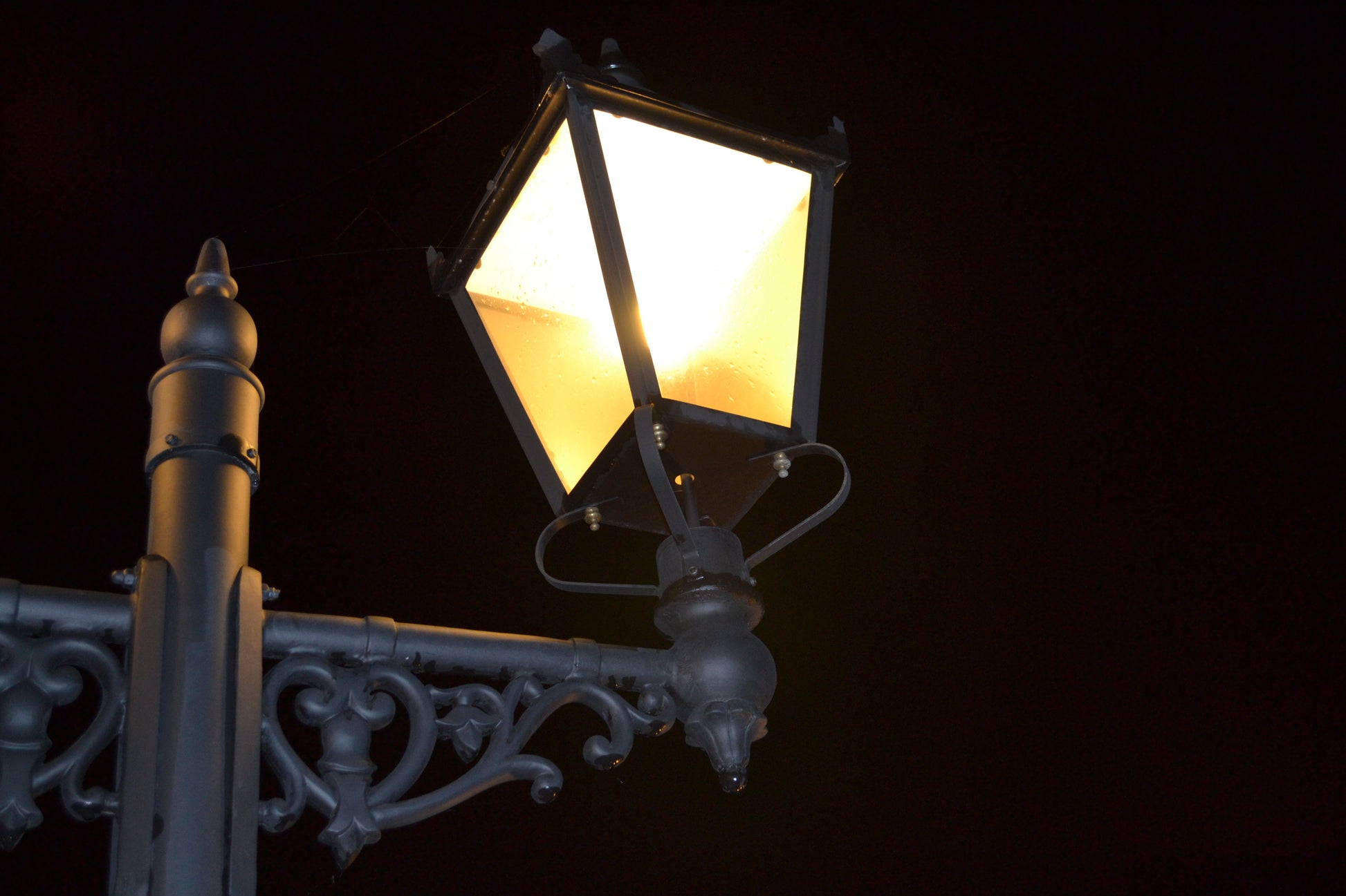 double headed black victorian lamp post at night