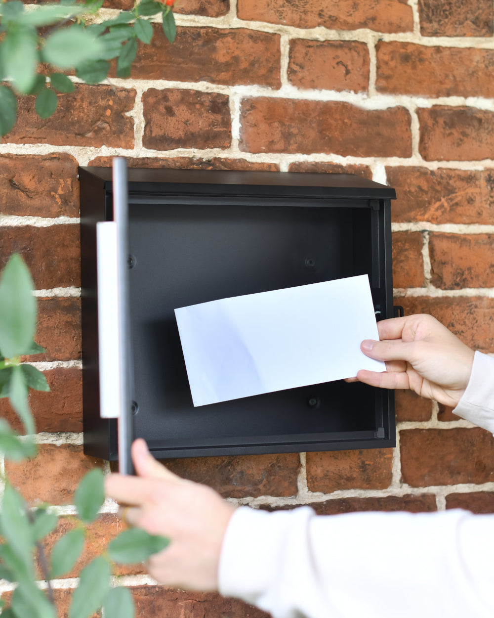 Hinged front opening post box door 