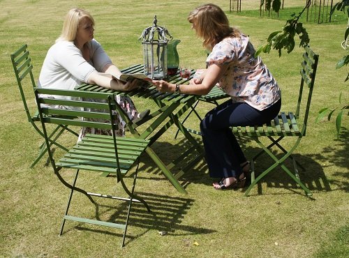 green table and chairs with people