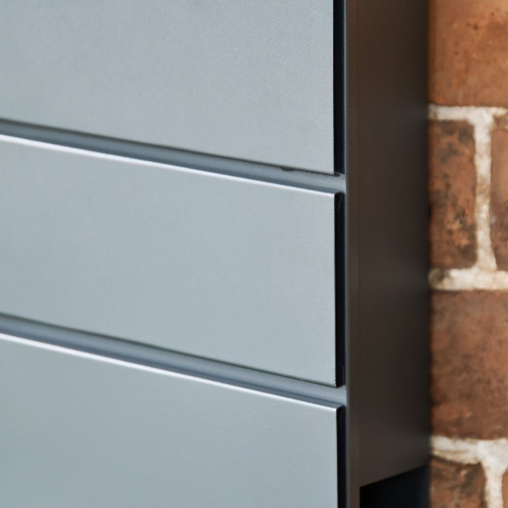 Side view of the grey post box