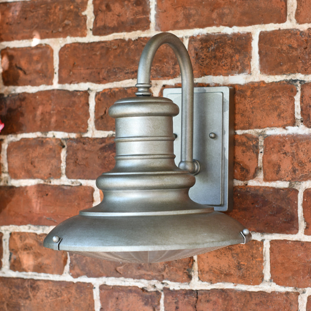 the tarnished wall light mounted to a brick wall