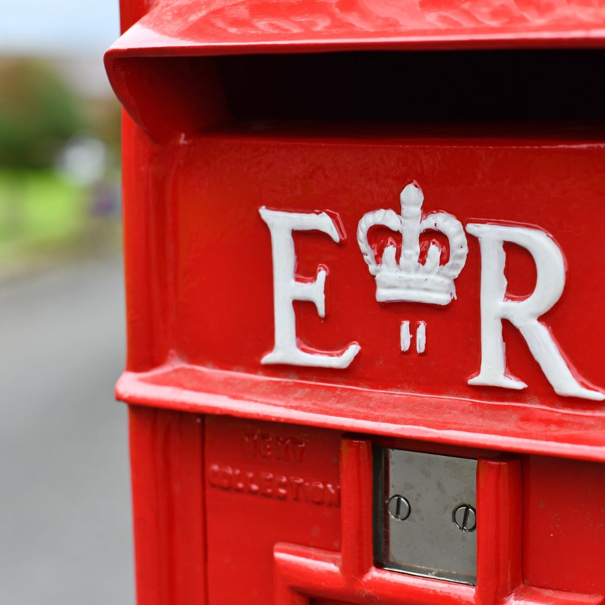 Close up of white and crown lettering on post box 