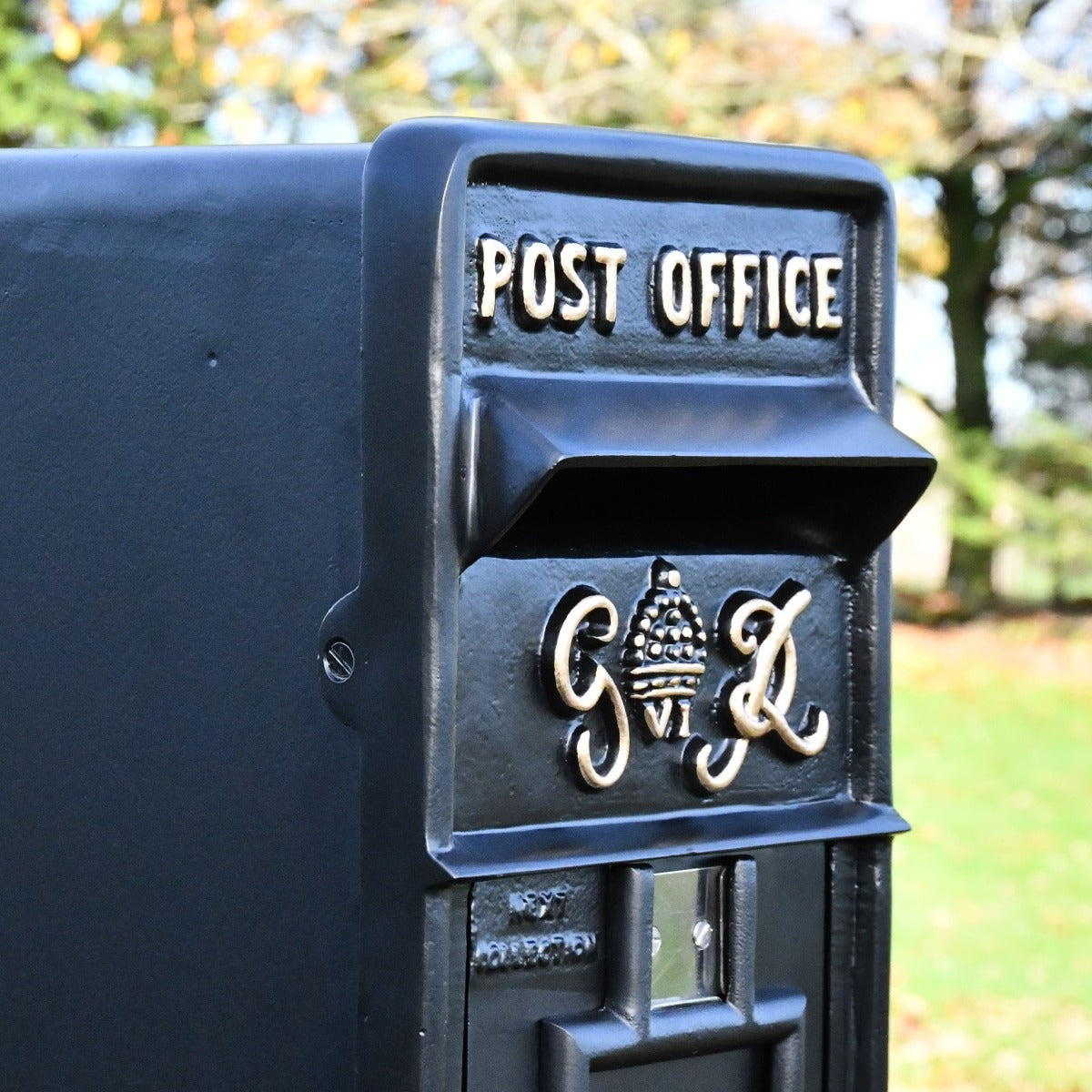 Side view of King George post box with gold lettering and hooded aperture 