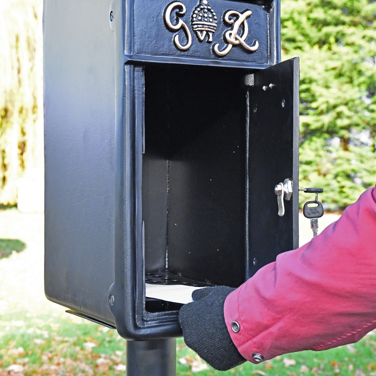 Close up of black King George post box with lockable door open 