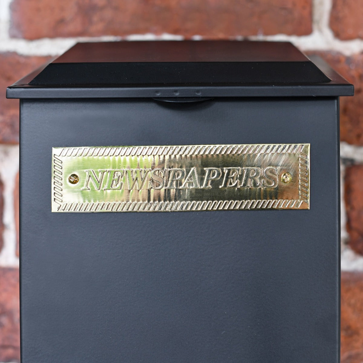 Close up of Black Newspaper Box with Brass Plaque 