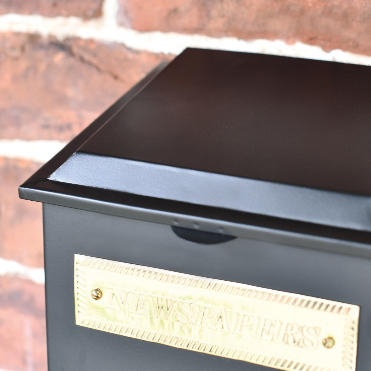 Close up of black Newspaper Box with Brass Plaque 