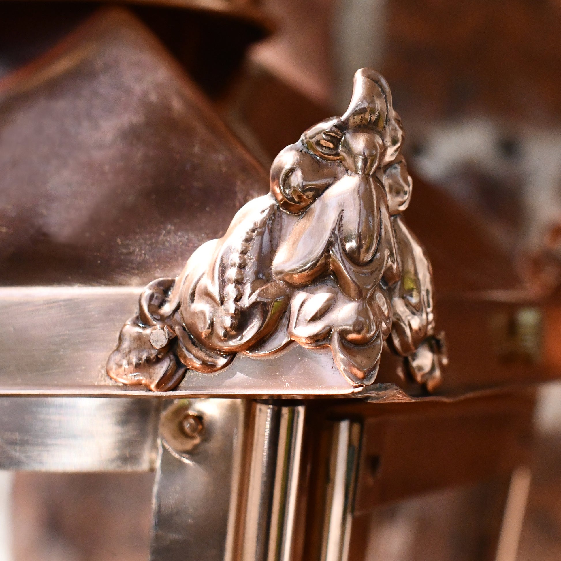 Corner finial on polished copper wall lantern