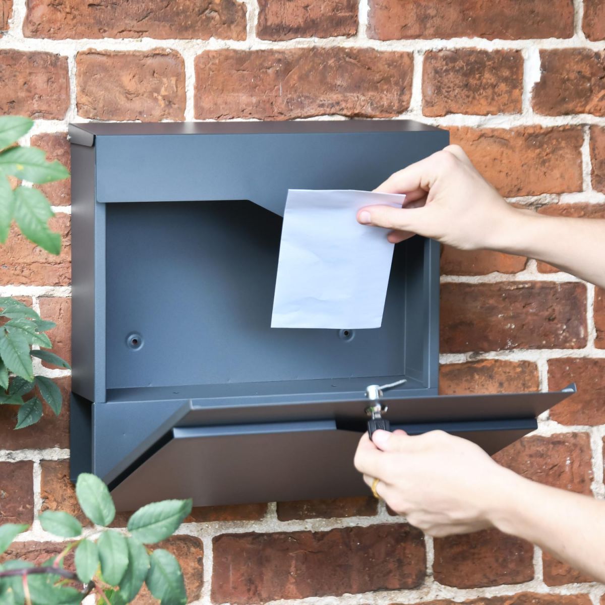 Mail being retrieved from the 'Paxton' Granite Grey Wall Mounted Post And Newspaper Holder