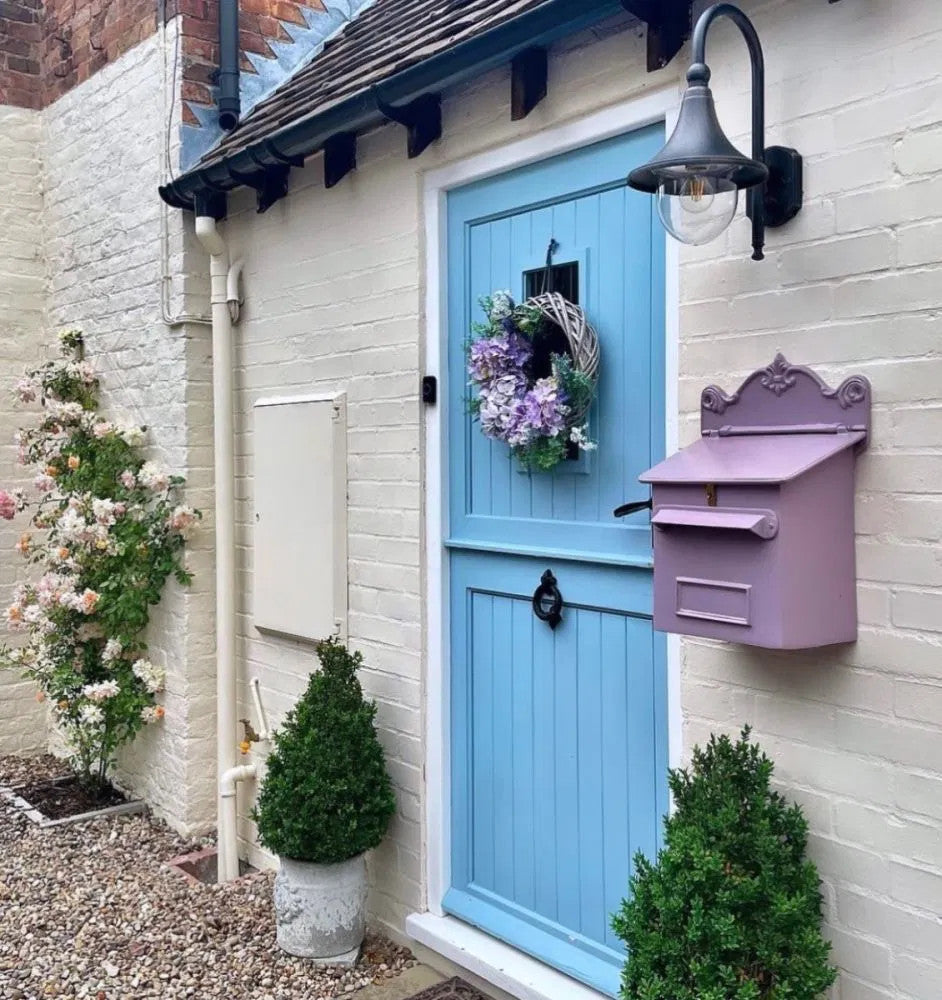 Lilac Cambourne Secure Parcel Box Wall Mount on a white brick wall