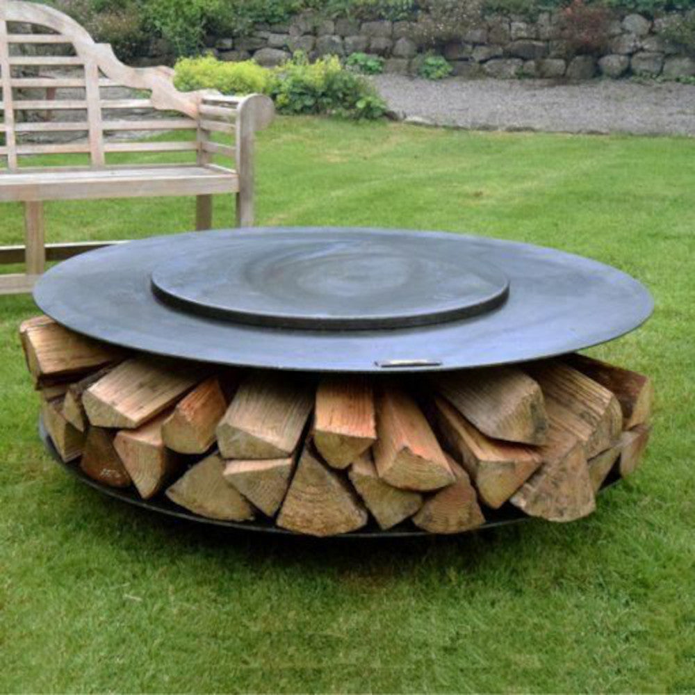 The circular fire pit with lid on acting as an outdoor table 