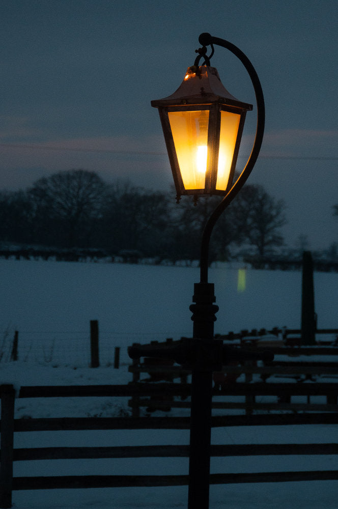 Swan Neck lantern lit up in the garden 