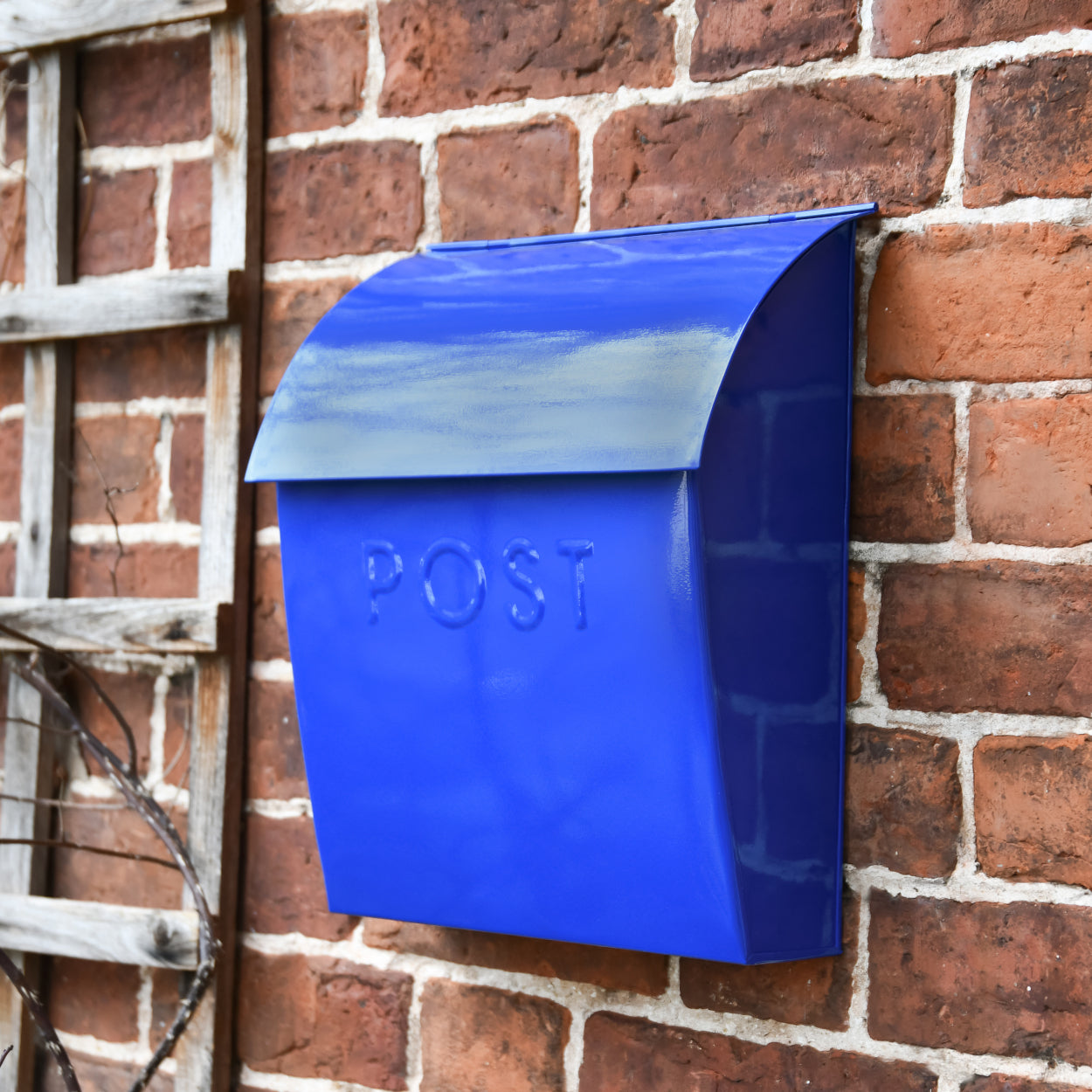 The dark blue post box on a brick wall