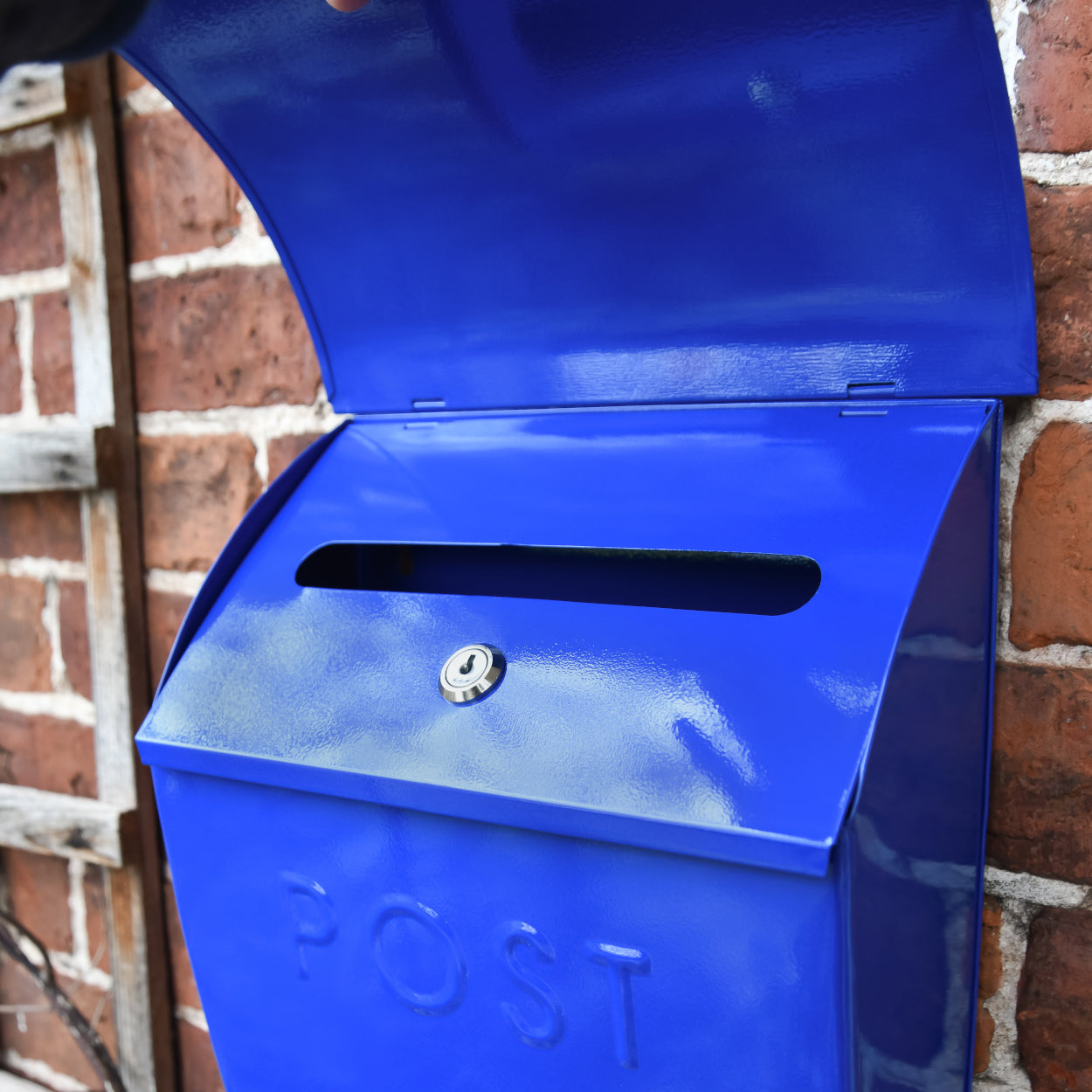 The letter flap on the lockable dark blue post box