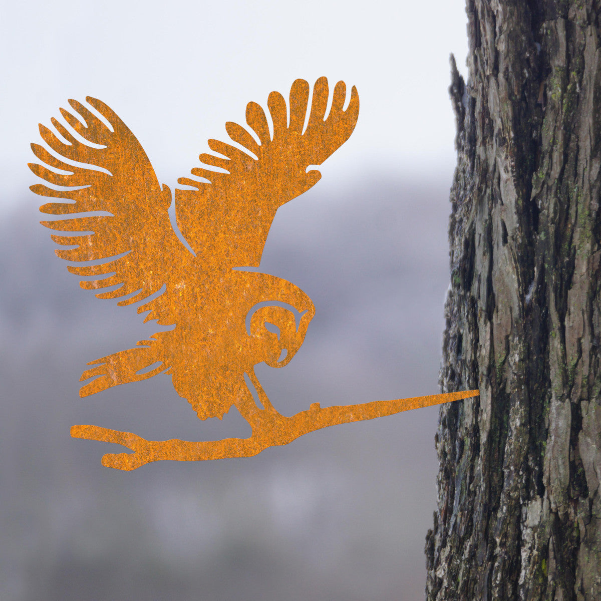 The ornate barn owl inserted into the tree on the left