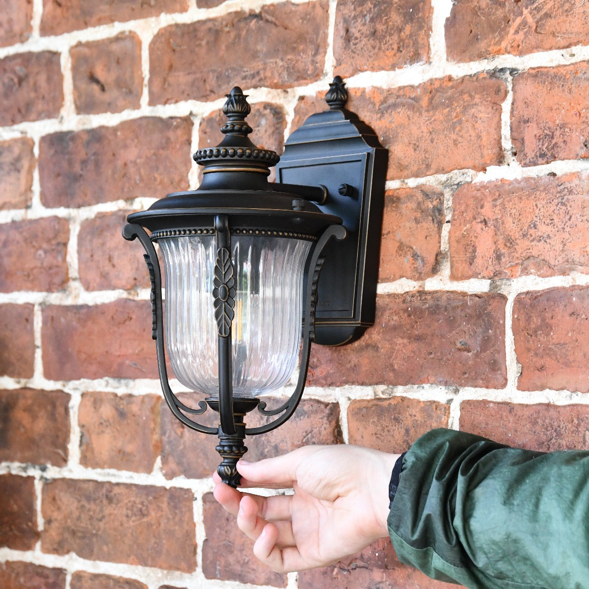 The Wilmont Bronze Ribbed Glass Wall Lantern With Hand For Scale