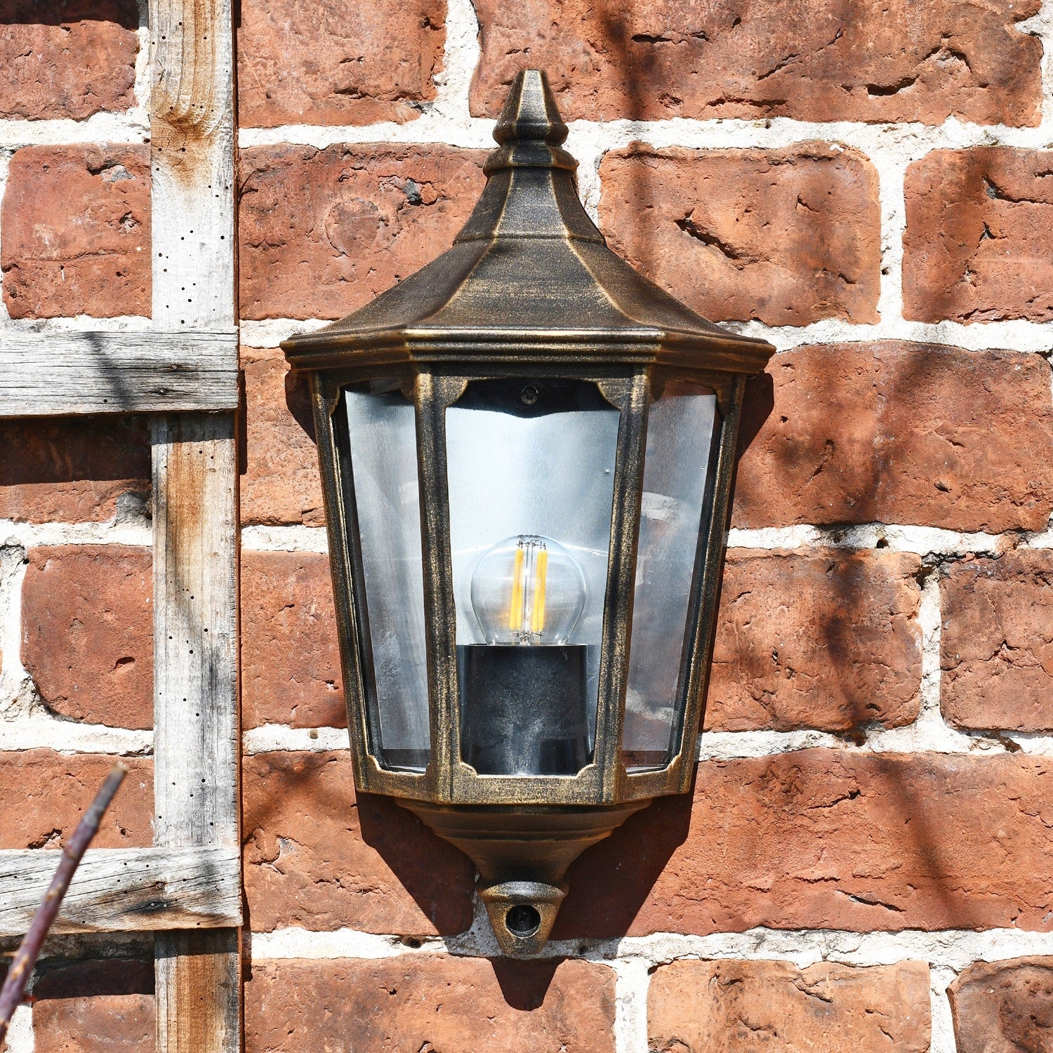 Traditional brushed gold porch light on brick wall