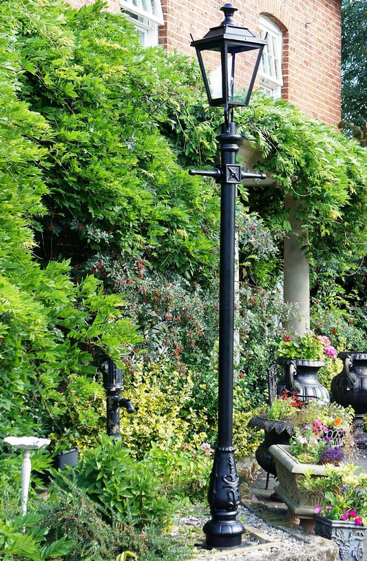Traditional Black Garden Lamp post in front of trees