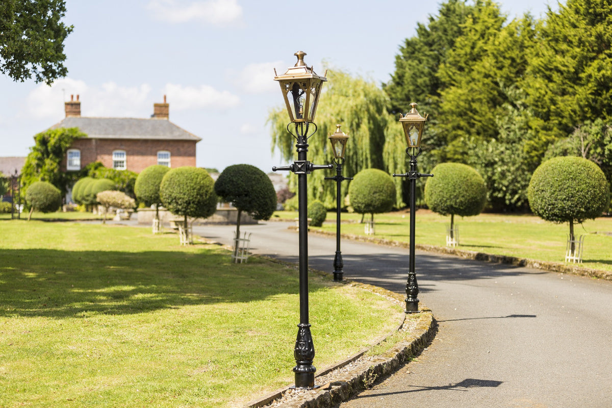 The brass lamp posts lined up on a driveway